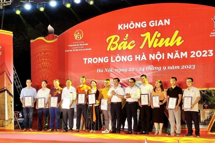Giám đốc Sở Văn hóa Thể thao Hà Nội Đỗ Đình Hồng và Giám đốc Sở VHTTDL Bắc Ninh Trịnh Hữu Hùng trao chứng nhận cho các nghệ nhân và đơn vị tham gia chương trình
